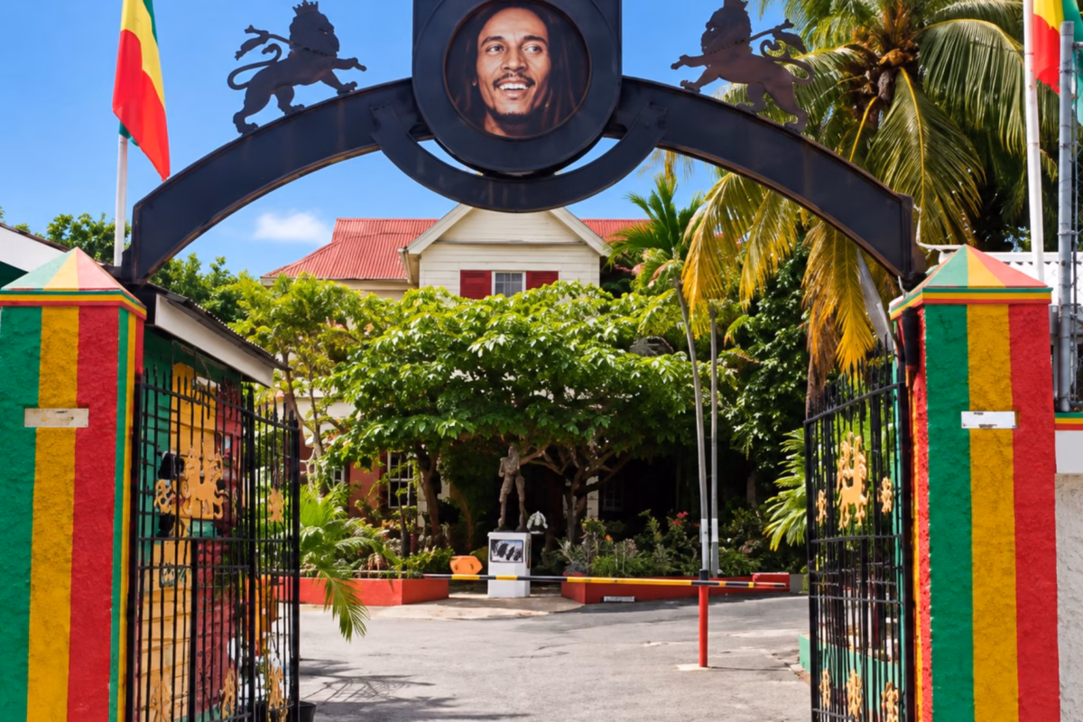 Entrance gates of the Bob Marley Museum with red, gold and green pillars
