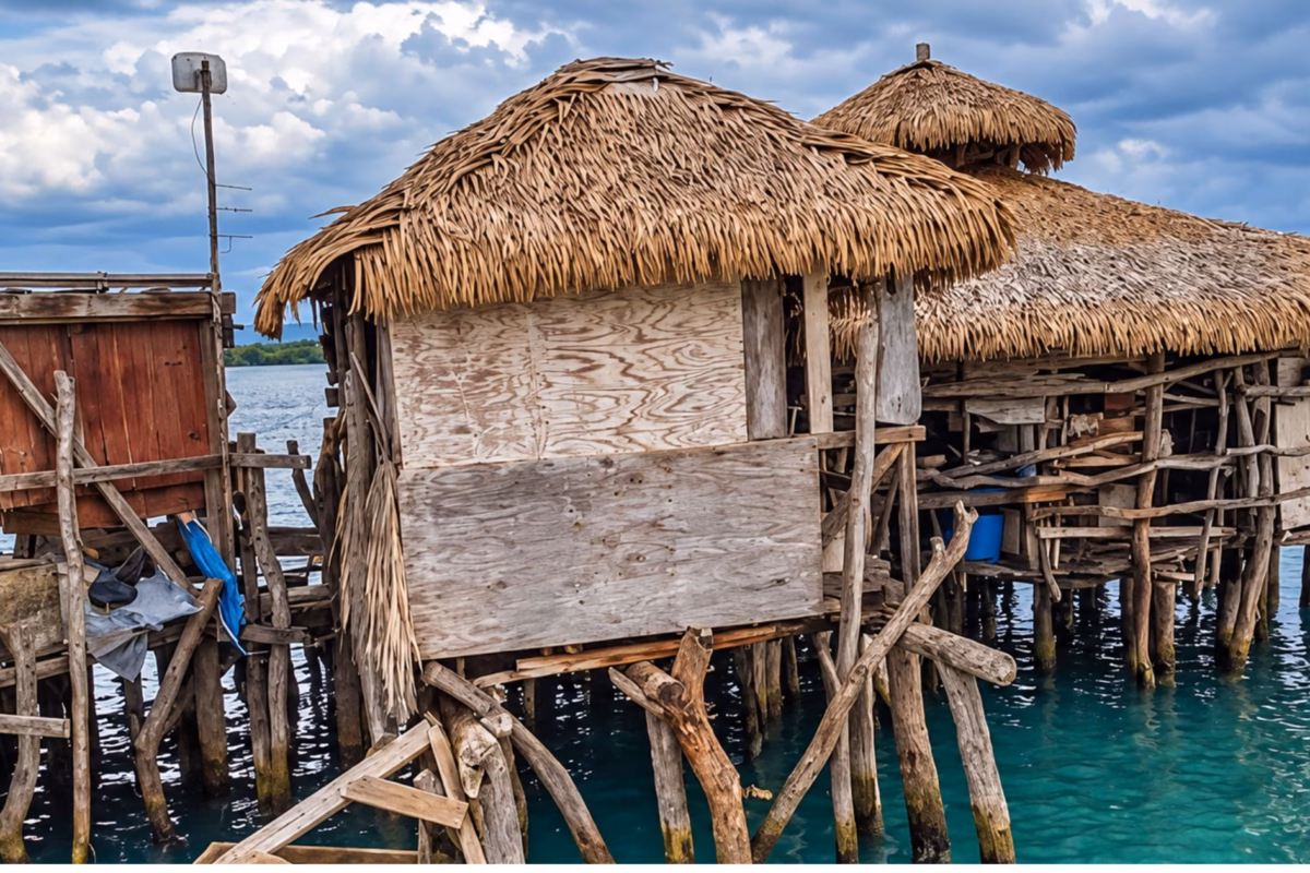 Thatched stilt huts of Floyd's Pelican Bar standing in shallow turquoise sea