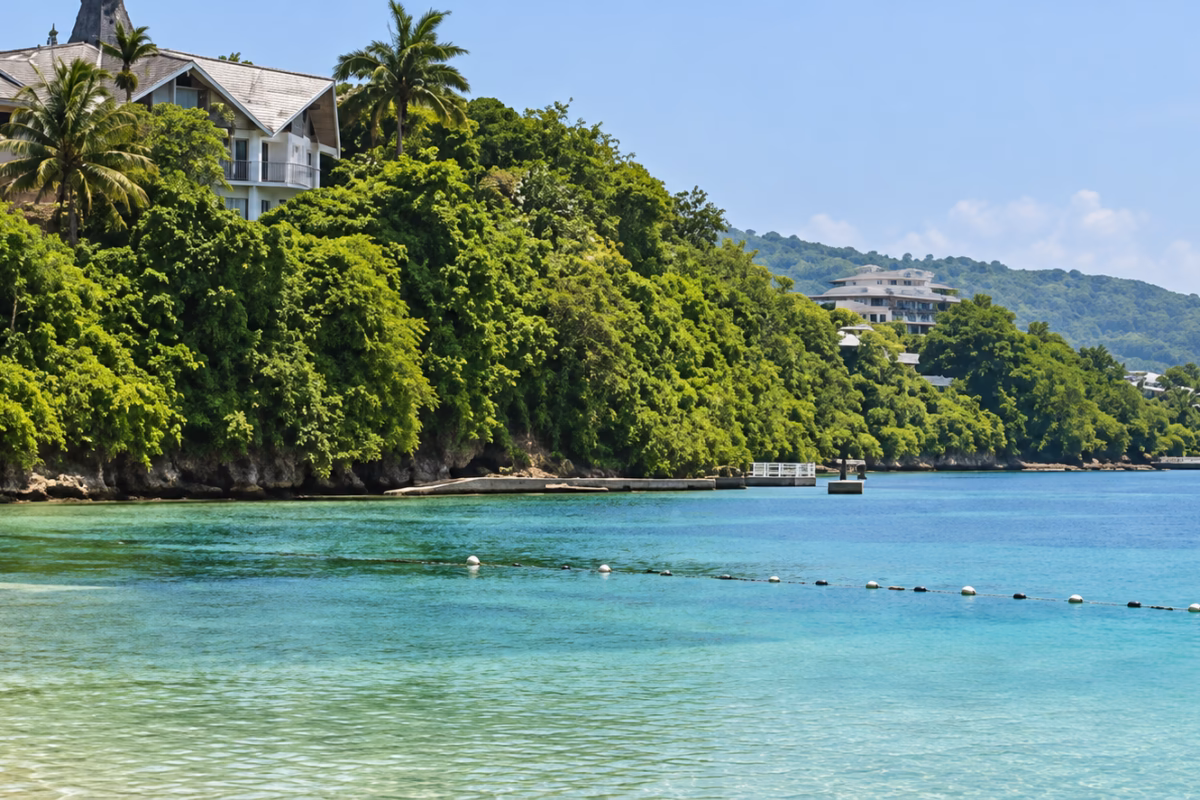 Calm turquoise water and wooded shoreline at Mahogany Beach