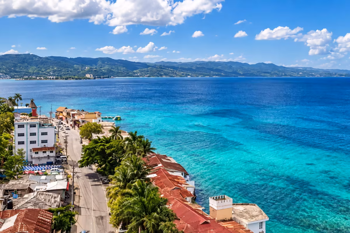 Aerial view of Montego Bay's Hip Strip along turquoise water with hills beyond